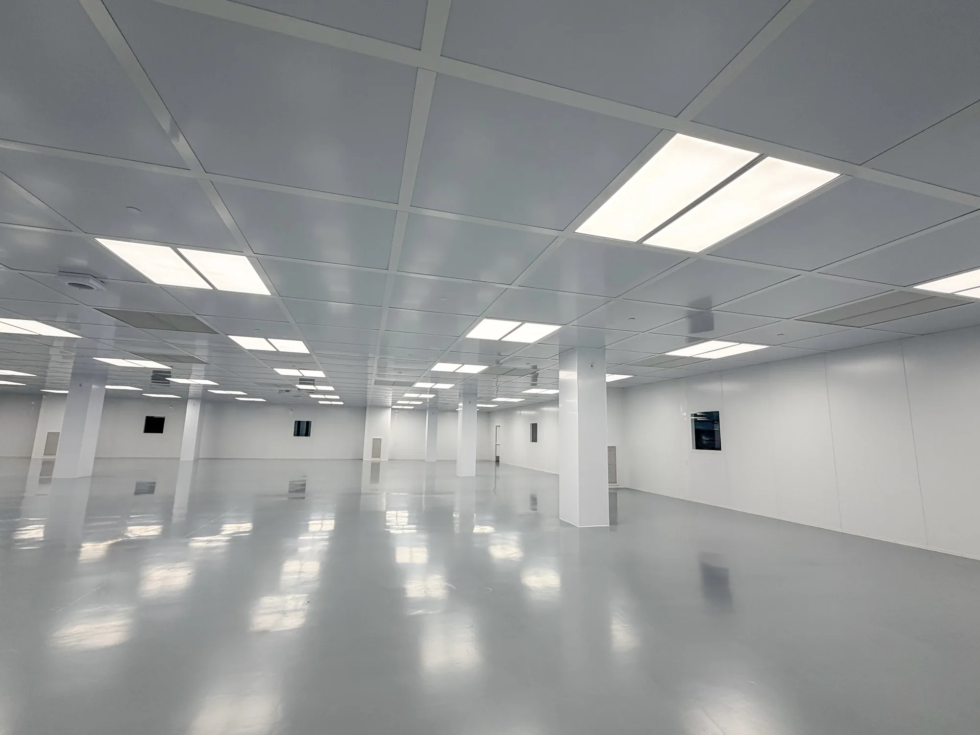 Interior of a completed modular wall room with suspended ceiling grid and lighting